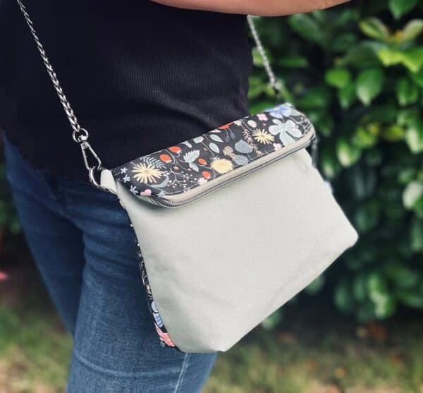 Moderne Umhängetasche mit Blumenmuster und verstellbarem Riemen.