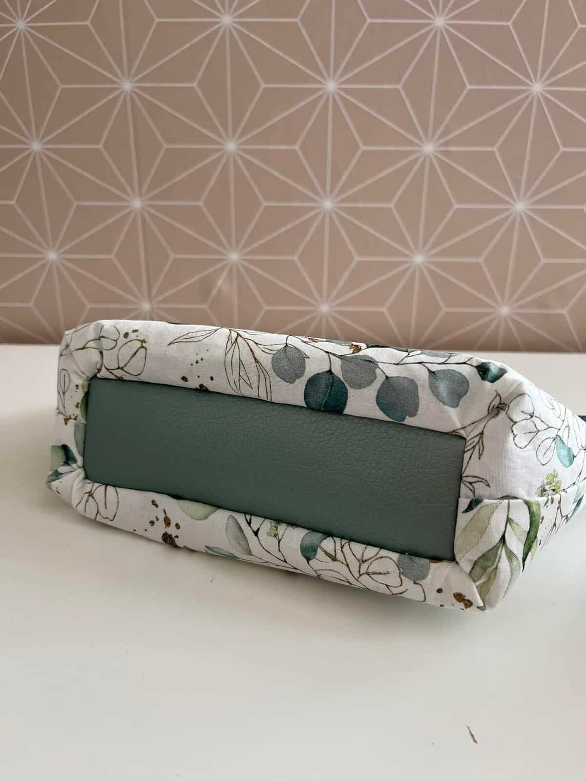 Selbstgenähte Kosmetiktasche mit Blumenmuster und grünem Innenfutter.