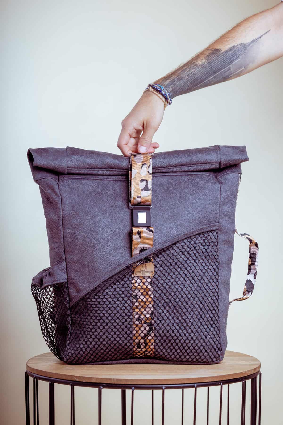 Stylish backpack with a roll-top design and mesh side pockets.