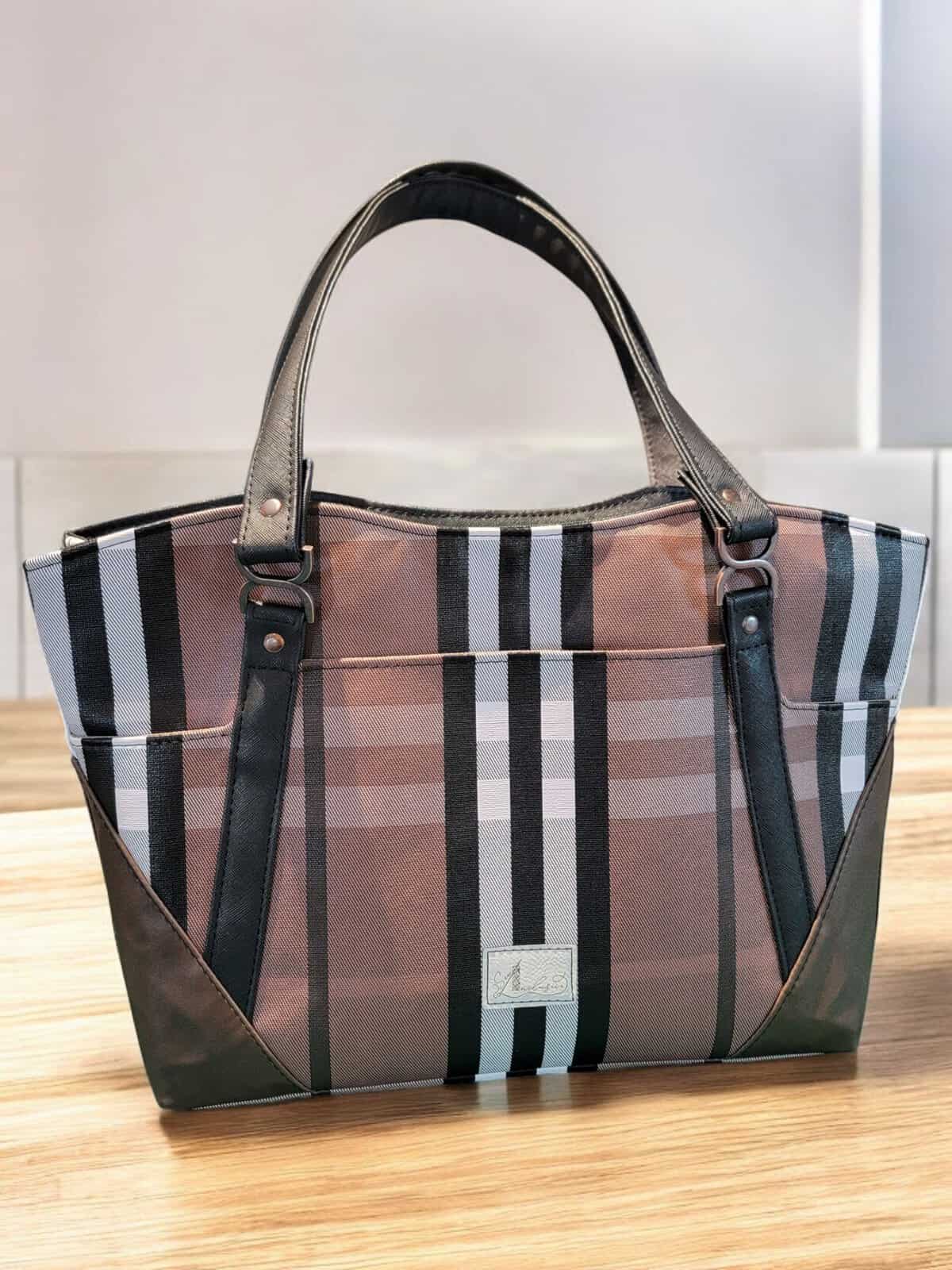 Elegant bag with a Burberry pattern in brown, black, and white.