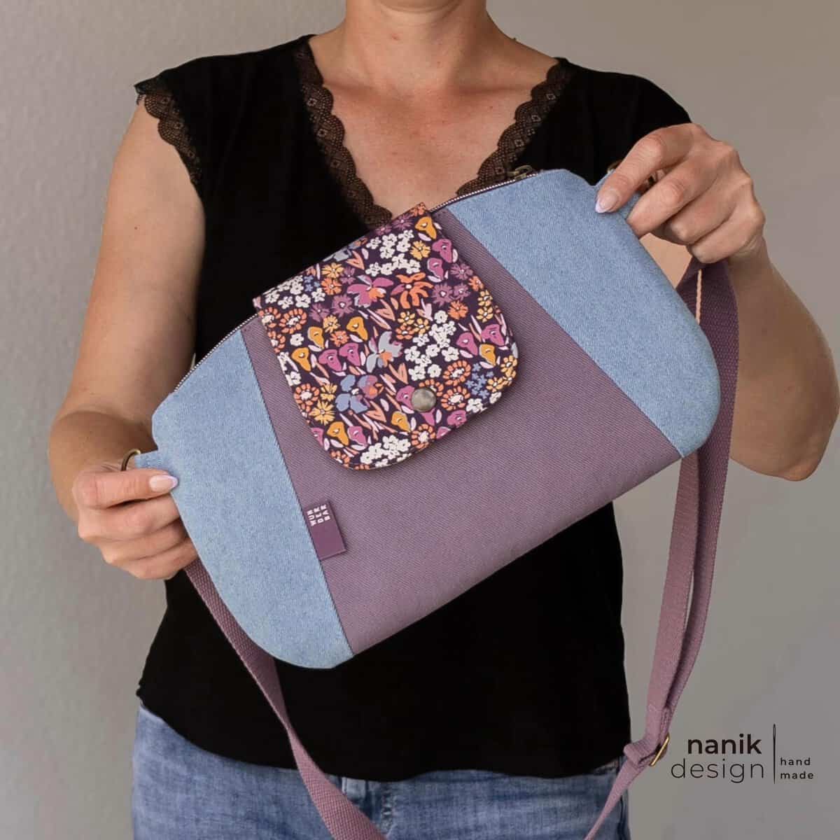 Schultertasche mit Blumenmuster, Lederelementen und verstellbarem Schultergurt.