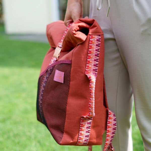 Rucksack mit buntem Muster und Mesh-Tasche, nah aufgenommen.