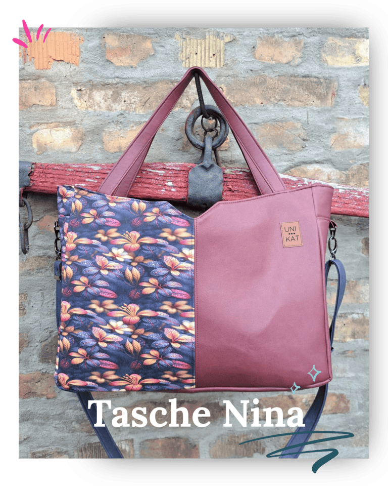 A stylish bag with a floral pattern and leather details in front of a brick wall.