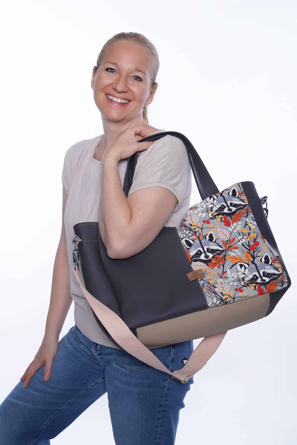Lächelnde Frau mit stilvoller Tasche vor weißem Hintergrund.