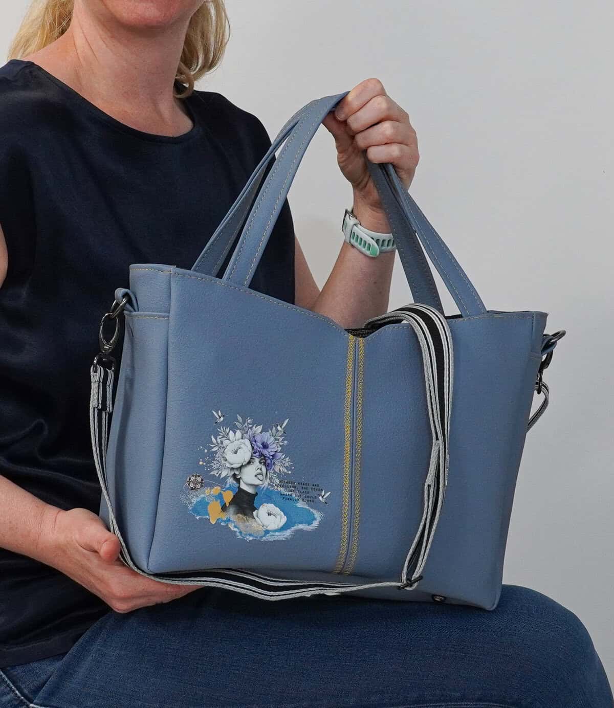 Bunte Handtasche mit floralem Design und Reißverschluss.