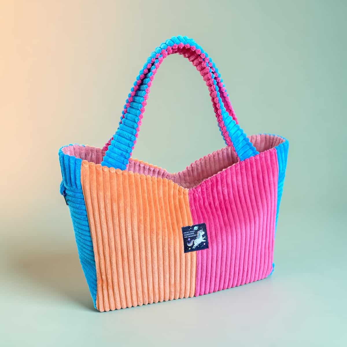 Bunte Cordtasche mit zwei Farben und bequemen Griffen.