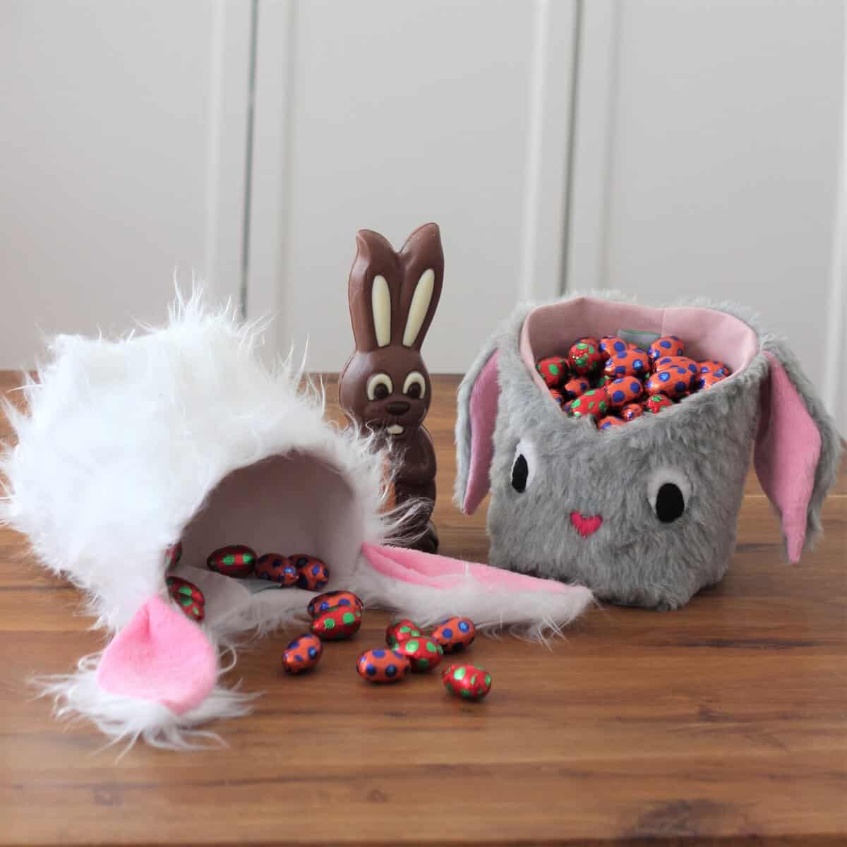 Niedliche Osterkörbchen und Hasenohren mit bunten Eiern.