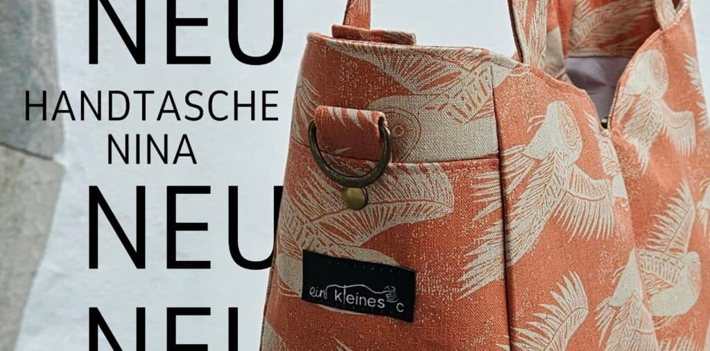 Handtasche mit Vogelmuster in Naturtönen, modisches Accessoire.