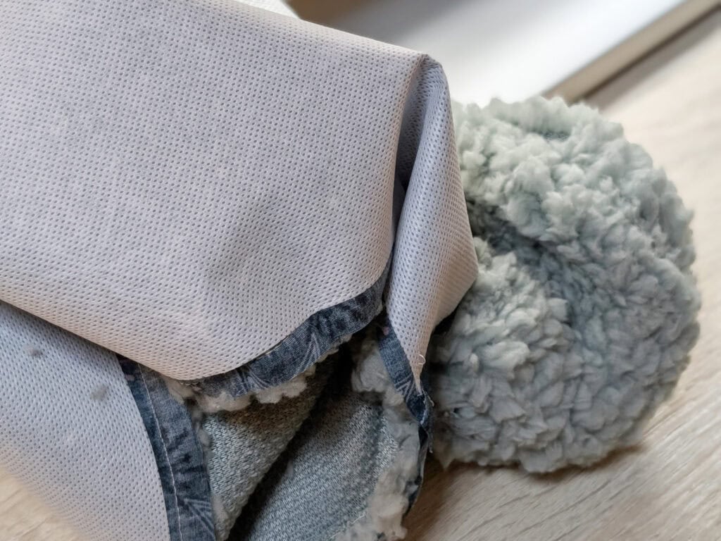Gemütliche Decke und Kissen auf einem Holztisch.