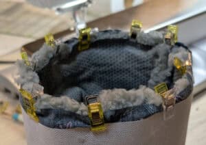 Isolierung eines zylindrischen Behälters mit Klammern und Dämmmaterial.