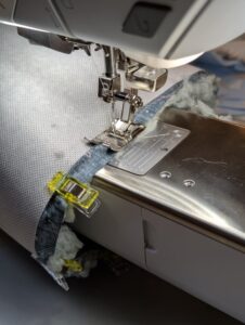 Nähmaschine näht Stoff mit professioneller Technik.