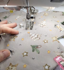 Nähen eines Weihnachtsbaums aus Stoff mit Nähmaschine.
