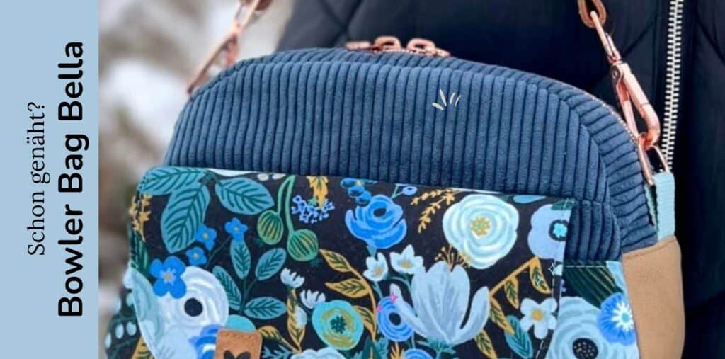 Bunter Bowler Bag Bella mit floralem Muster und blauer Quaste.