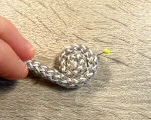 Handnähen eines Seil-Körbchens mit Nadel und Faden.