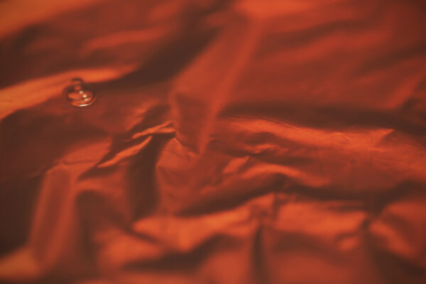 Roter Oilskin Stoff mit Wassertröpfchen für Taschen nähen.